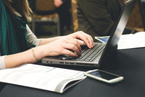 Woman typing an SEO article on a computer